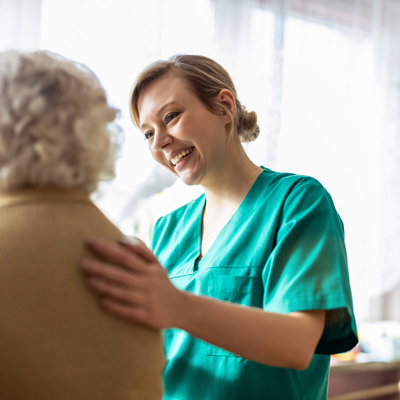 smiling caregiver interacting with elderly woman in bright room compassionate care support 3 elderly care assistants