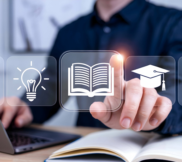 man interacting with educational icons including a book light bulb and graduation cap on a digital screen with a laptop and open book in the background learning 2 digital tools 2 education
