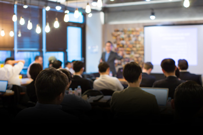 business meeting with presenter and audience in modern office setting focused on discussing seven key strategies for success