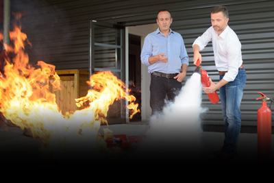 two men performing fire extinguisher training on flames demonstrating safety techniques in a controlled environment seven steps to effective fire response